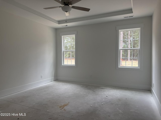 unfurnished room with a raised ceiling, baseboards, ceiling fan, and concrete floors