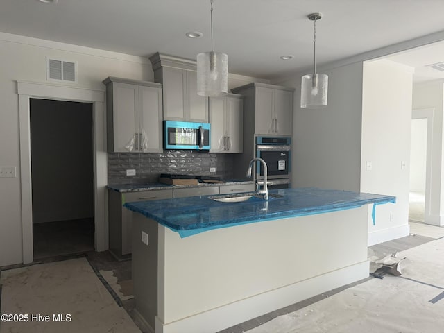 kitchen with a sink, stainless steel appliances, gray cabinets, backsplash, and recessed lighting