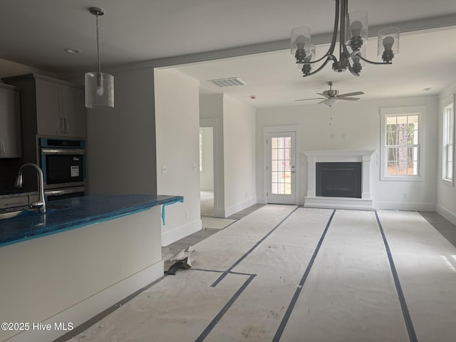 kitchen with a sink, baseboards, plenty of natural light, and stainless steel double oven