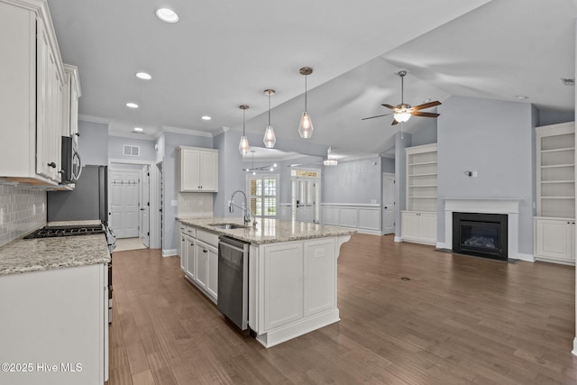 kitchen featuring a sink, stainless steel appliances, a ceiling fan, open floor plan, and white cabinetry
