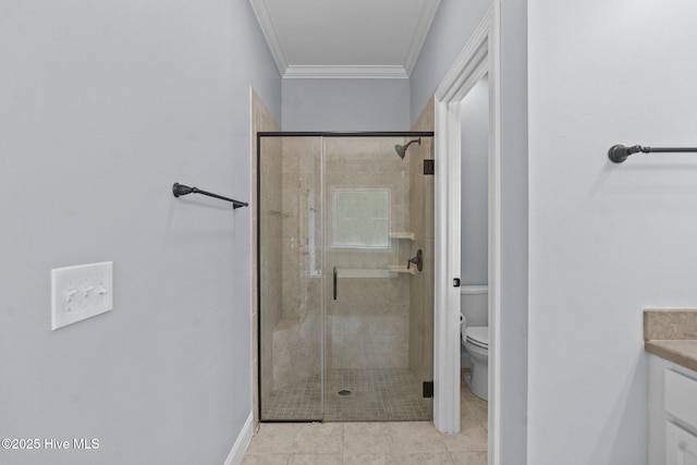 bathroom featuring a stall shower, crown molding, toilet, vanity, and baseboards