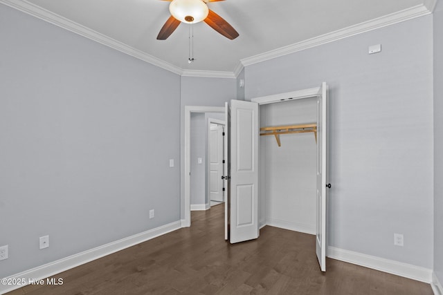 unfurnished bedroom with crown molding, dark wood finished floors, baseboards, a closet, and ceiling fan