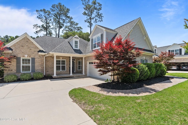 view of front of property with driveway, brick siding, roof with shingles, a front yard, and a garage