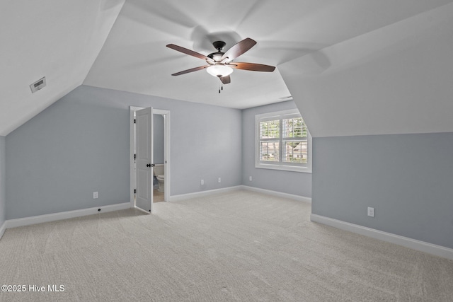 additional living space featuring ceiling fan, vaulted ceiling, light colored carpet, and baseboards