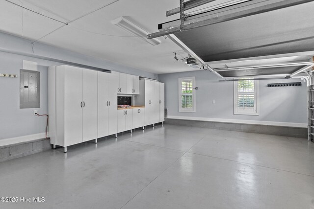 garage with electric panel, a garage door opener, and baseboards