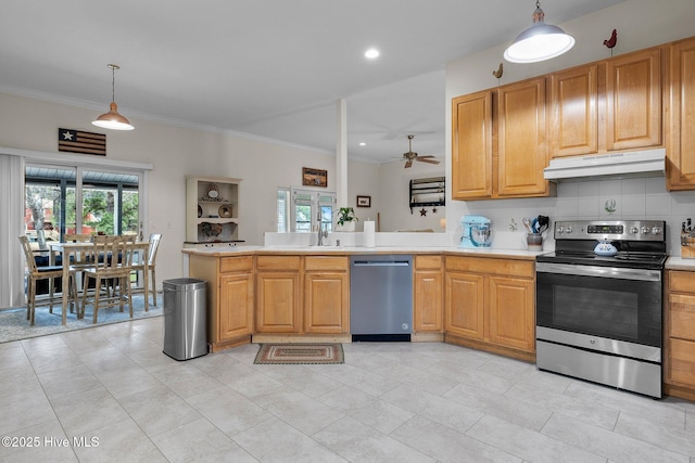 101 Mallard Dr, Currituck, NC 27929 - kitchen with appliances with stainless steel finishes, under cabinet range hood, ornamental molding, healthy amount of natural light, and a peninsula