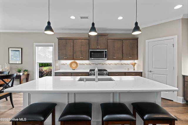 3032 Beachcomber Dr, Southport, NC 28461 - kitchen featuring stainless steel appliances, a sink, backsplash, ornamental molding, and wood finished floors