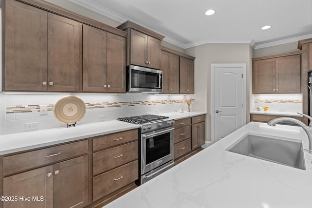 3032 Beachcomber Dr, Southport, NC 28461 - kitchen with stainless steel appliances, a sink, ornamental molding, decorative backsplash, and light stone countertops