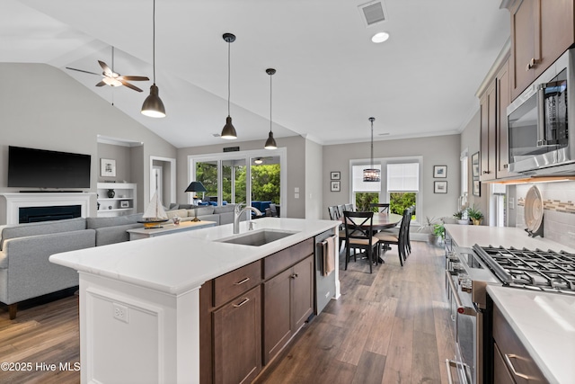 3032 Beachcomber Dr, Southport, NC 28461 - kitchen with appliances with stainless steel finishes, a sink, dark wood-type flooring, light countertops, and vaulted ceiling