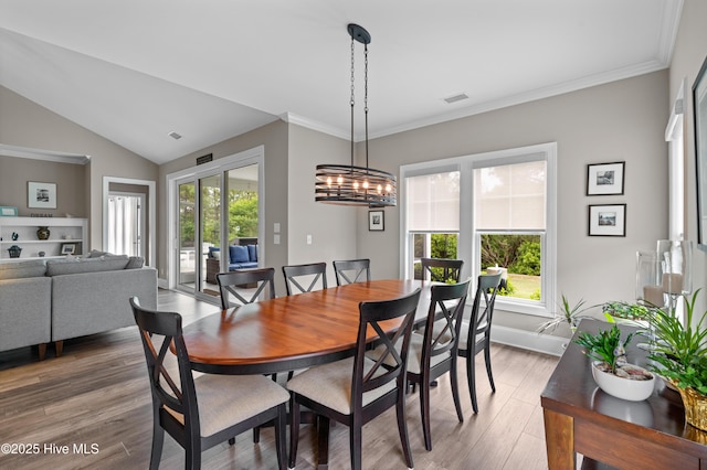 3032 Beachcomber Dr, Southport, NC 28461 - dining room with light wood-style flooring, baseboards, vaulted ceiling, and crown molding