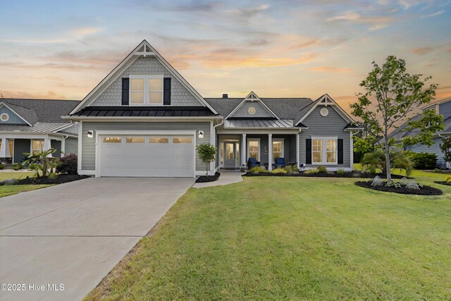 3032 Beachcomber Dr, Southport, NC 28461 - view of front of house featuring a standing seam roof, a front yard, driveway, a garage, and metal roof