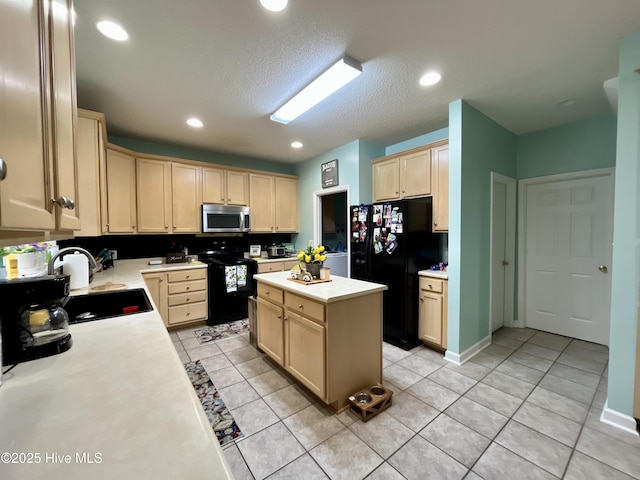 kitchen with black appliances, light brown cabinetry, a sink, light countertops, and light tile patterned flooring