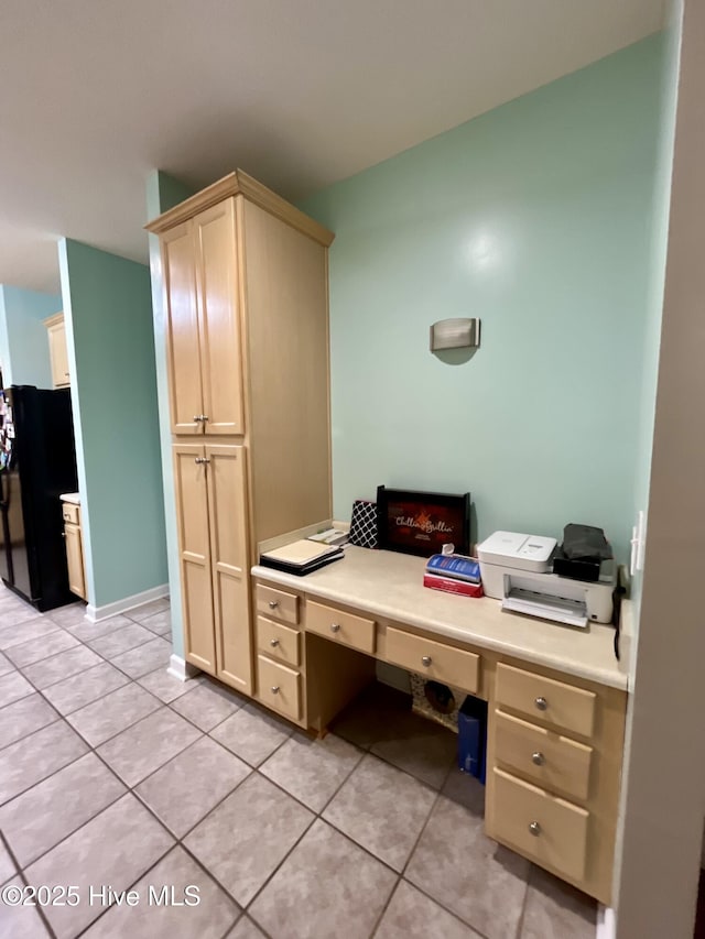 home office with built in study area, light tile patterned floors, and baseboards