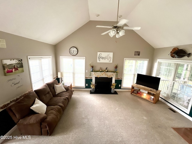 living room featuring carpet, high vaulted ceiling, healthy amount of natural light, ceiling fan, and a fireplace with flush hearth