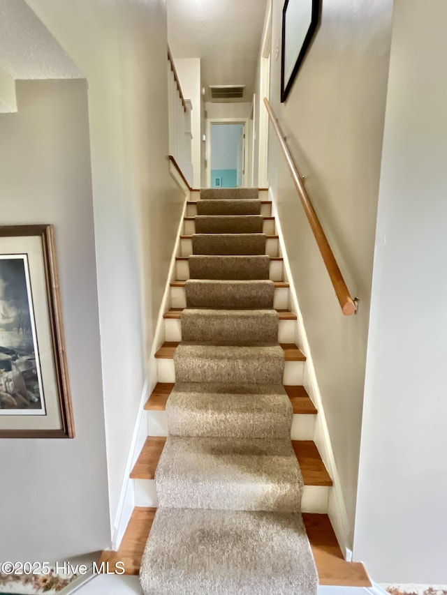 stairway featuring wood finished floors and baseboards