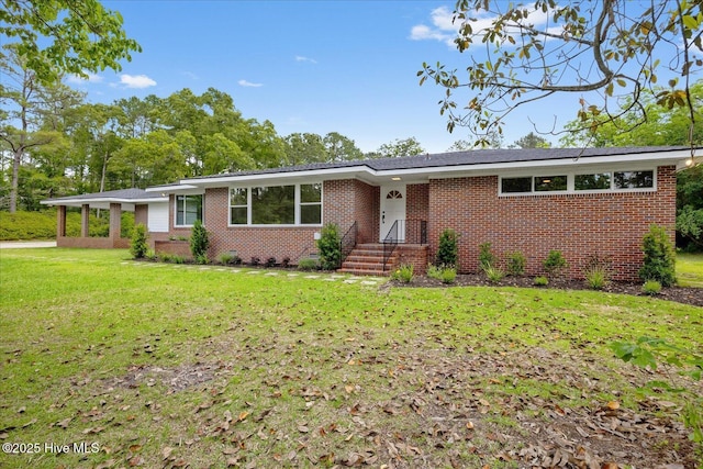 single story home featuring brick siding and a front lawn
