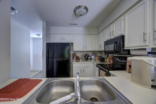 2726 S 17th St Unit C, Wilmington, NC 28412 - kitchen with black appliances, light countertops, white cabinetry, a textured ceiling, and a sink