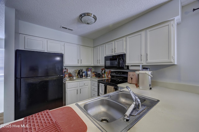 2726 S 17th St Unit C, Wilmington, NC 28412 - kitchen with black appliances, a sink, white cabinets, light countertops, and a textured ceiling