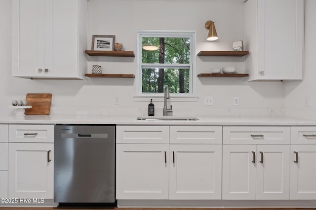 kitchen featuring stainless steel dishwasher, a sink, open shelves, and white cabinetry