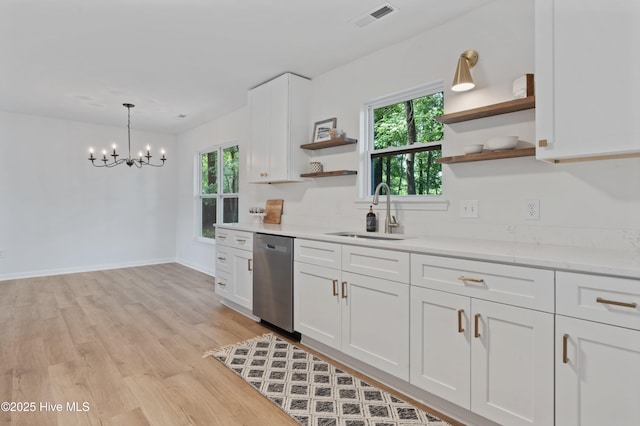 kitchen featuring dishwasher, open shelves, a sink, light countertops, and a chandelier