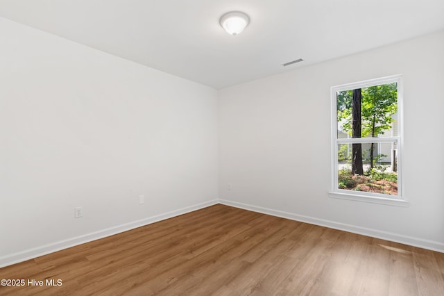 unfurnished room with light wood finished floors and baseboards