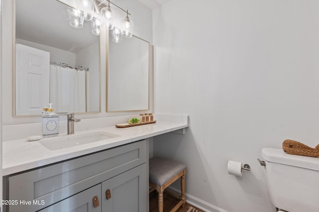 full bath with toilet, baseboards, vanity, and wood finished floors
