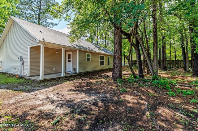 view of front of house featuring roof with shingles and fence