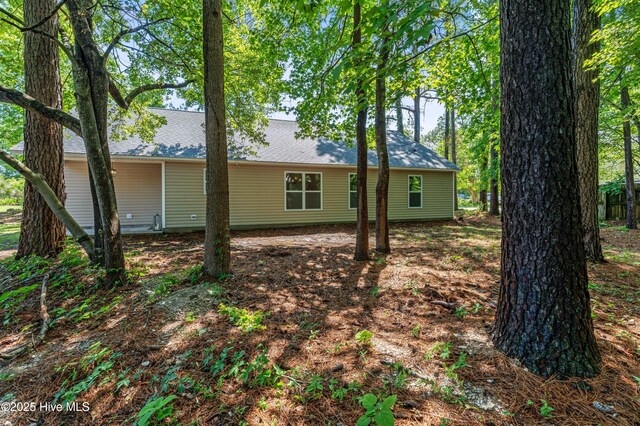 rear view of property with a shingled roof