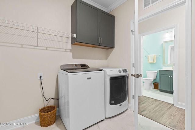 113 Eagle Claw Dr, Calabash, NC 28467 - laundry room featuring cabinet space, washer and dryer, ornamental molding, light marble finish floors, and baseboards