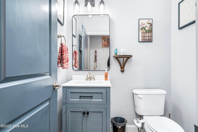 bathroom with vanity, baseboards, and toilet