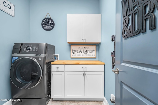 clothes washing area featuring hookup for a washing machine and cabinet space