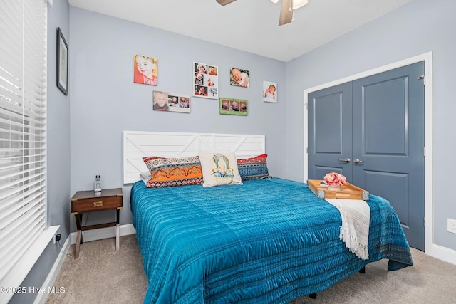 carpeted bedroom with ceiling fan, baseboards, and a closet