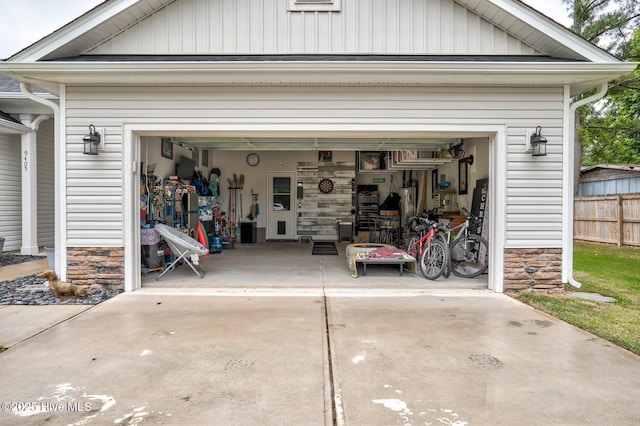 garage with fence and concrete driveway