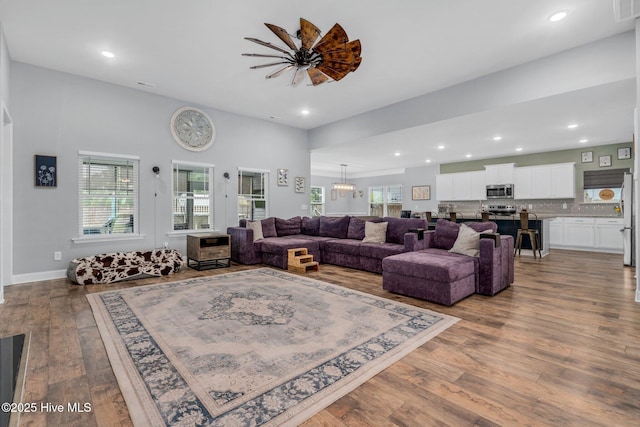living area with wood finished floors, plenty of natural light, and recessed lighting