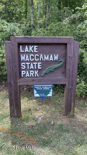 community / neighborhood sign with a forest view