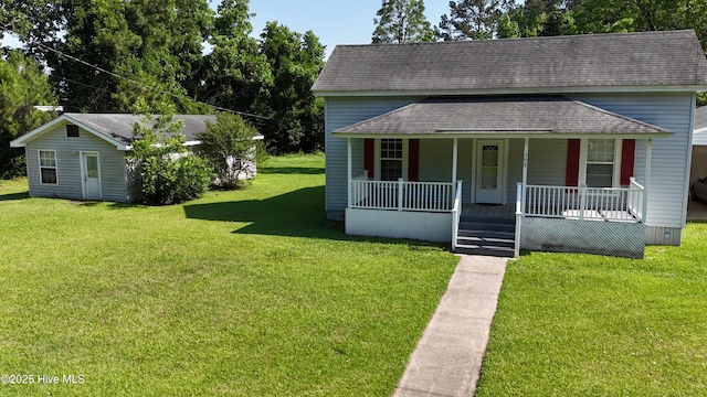 view of front facade with a porch, a shingled roof, and a front yard
