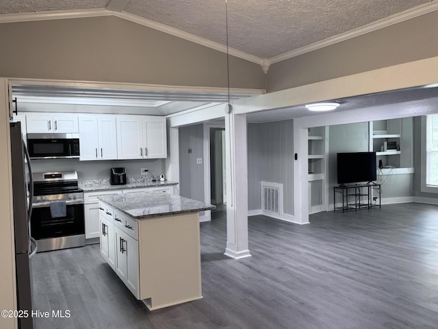 kitchen with stainless steel appliances, open floor plan, white cabinets, dark wood-style floors, and a textured ceiling