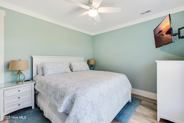 201 W Yacht Dr, Oak Island, NC 28465 - bedroom with baseboards, wood finished floors, and ceiling fan