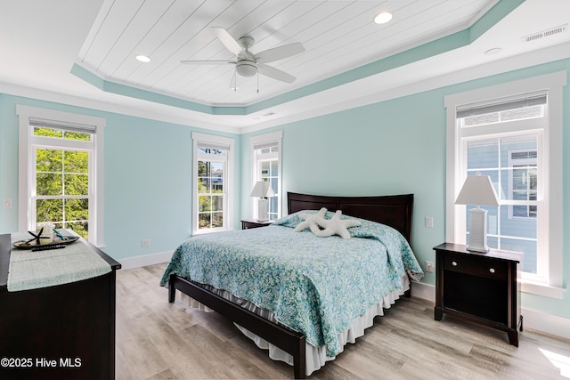 201 W Yacht Dr, Oak Island, NC 28465 - bedroom featuring a raised ceiling, light wood-style floors, multiple windows, baseboards, and recessed lighting