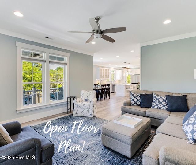 201 W Yacht Dr, Oak Island, NC 28465 - living room featuring light wood-style floors, recessed lighting, ceiling fan, a chandelier, and crown molding