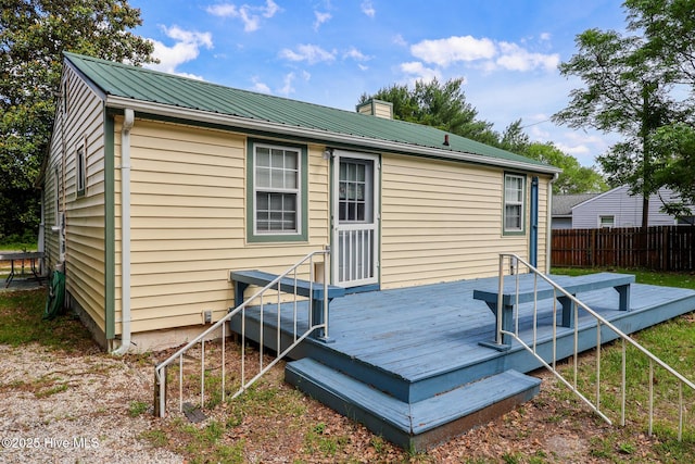 178 Stanley St, West End, NC 27376 - rear view of house with fence, a chimney, a wooden deck, and metal roof