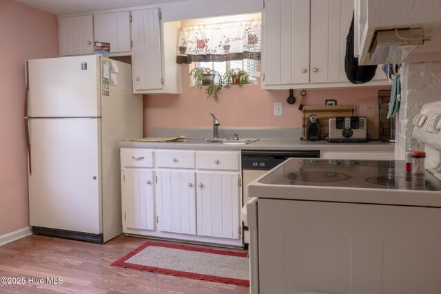 178 Stanley St, West End, NC 27376 - kitchen featuring freestanding refrigerator, range, a sink, white cabinets, and light wood-style flooring