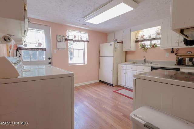 178 Stanley St, West End, NC 27376 - kitchen with freestanding refrigerator, a sink, washing machine and clothes dryer, a textured ceiling, and light wood-type flooring