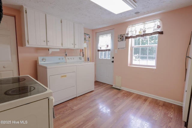 178 Stanley St, West End, NC 27376 - laundry area with light wood-style flooring, washing machine and dryer, a textured ceiling, and baseboards