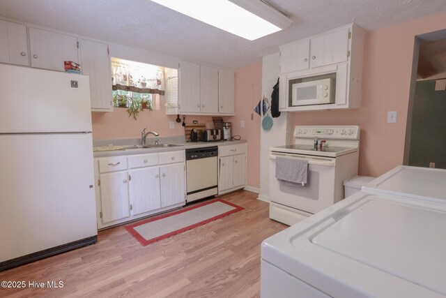 178 Stanley St, West End, NC 27376 - kitchen featuring white appliances, a sink, light wood-type flooring, white cabinetry, and light countertops