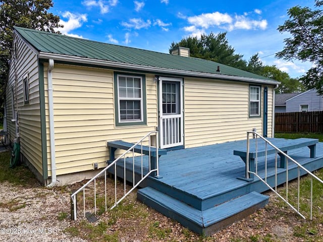 178 Stanley St, West End, NC 27376 - back of house featuring a deck, fence, metal roof, and a chimney