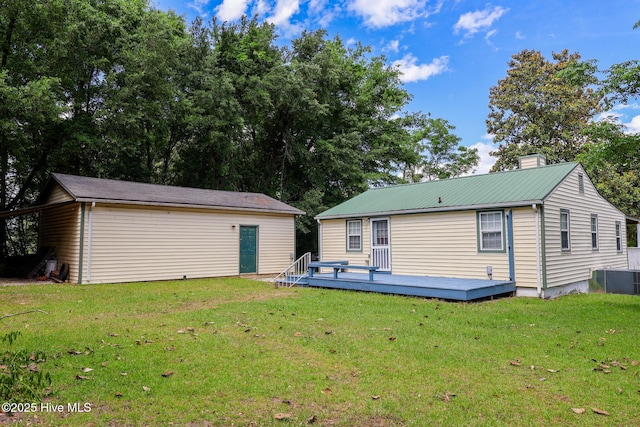 178 Stanley St, West End, NC 27376 - rear view of property featuring a deck, a lawn, an outdoor structure, and a chimney