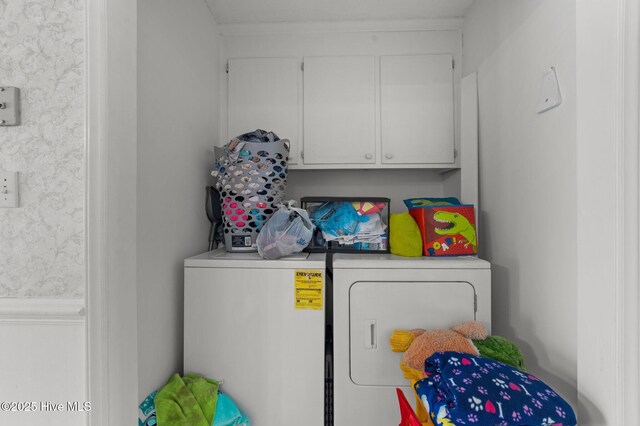 clothes washing area with washer and dryer and cabinet space