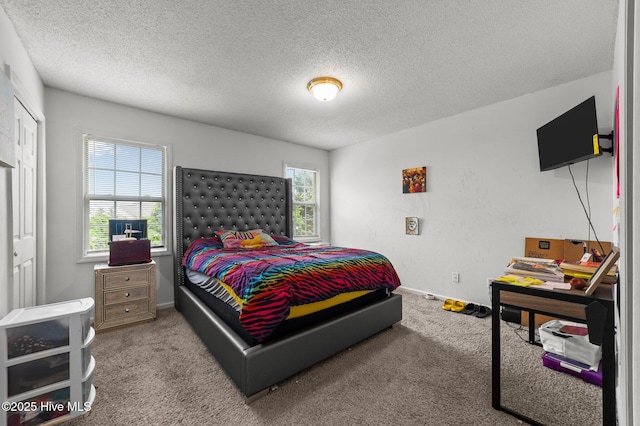 bedroom featuring carpet, baseboards, and a textured ceiling