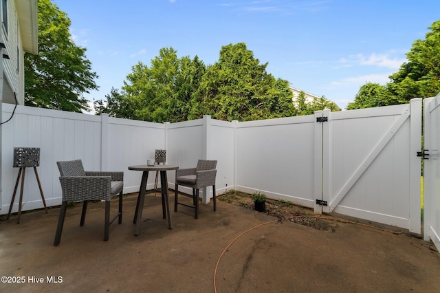 view of patio / terrace with a gate, a fenced backyard, and outdoor dining area